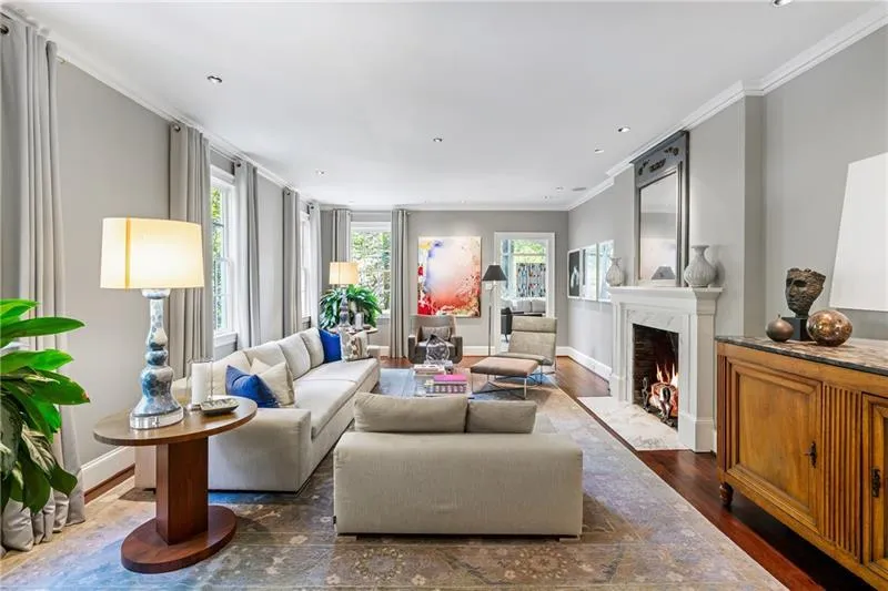 Living area with wood finished floors, ornamental molding, a high end fireplace, baseboards, and recessed lighting