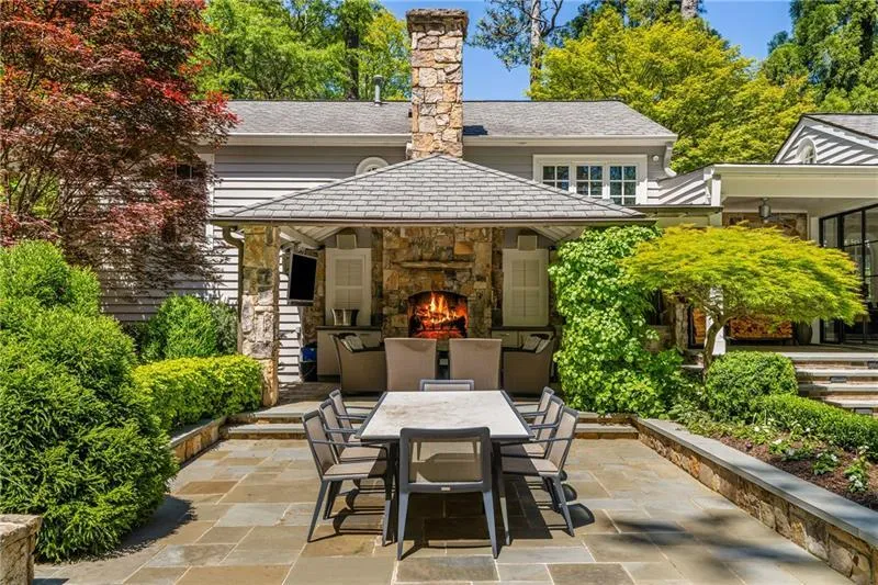 View of patio / terrace with an outdoor stone fireplace and outdoor dining space