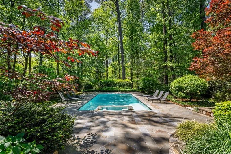 View of swimming pool featuring a patio area and a pool with connected hot tub