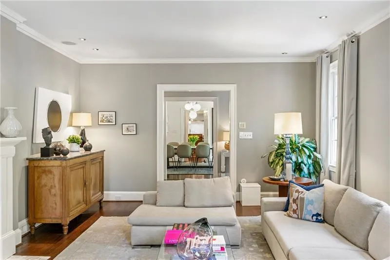 Living area featuring wood finished floors, crown molding, baseboards, and recessed lighting