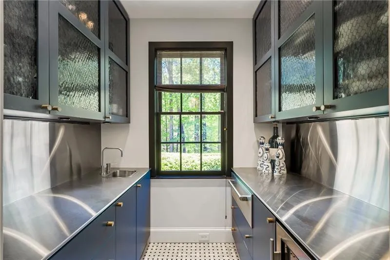Bar with a sink, baseboards, healthy amount of natural light, and tile patterned floors