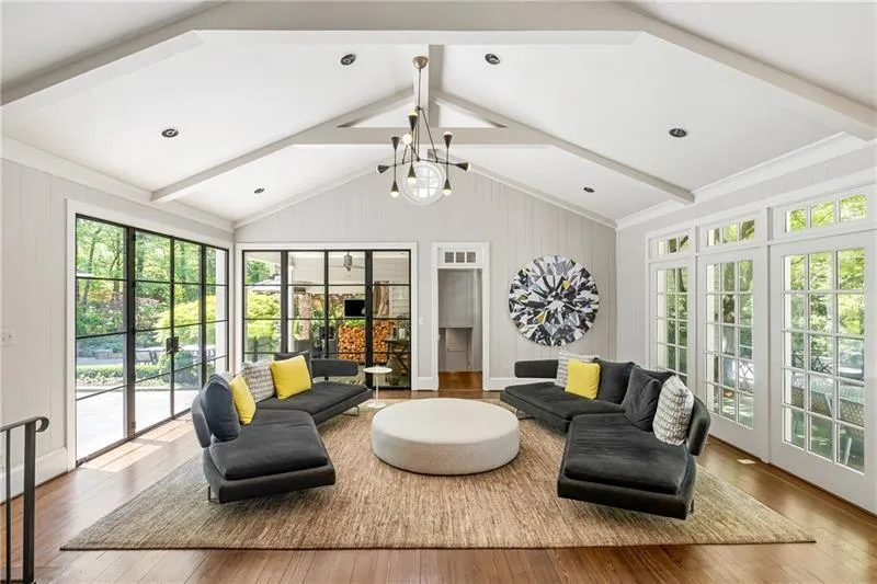 Living area featuring healthy amount of natural light, wood-type flooring, and a chandelier