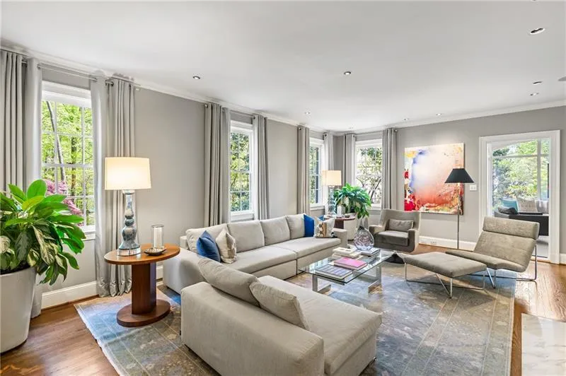 Living area with ornamental molding, wood finished floors, baseboards, plenty of natural light, and recessed lighting