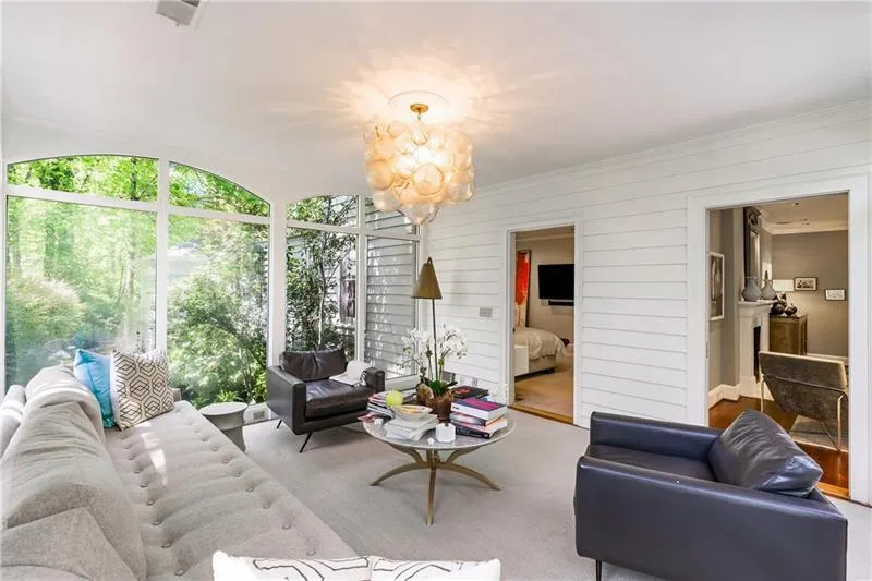 Living room featuring a chandelier, crown molding, and wood walls