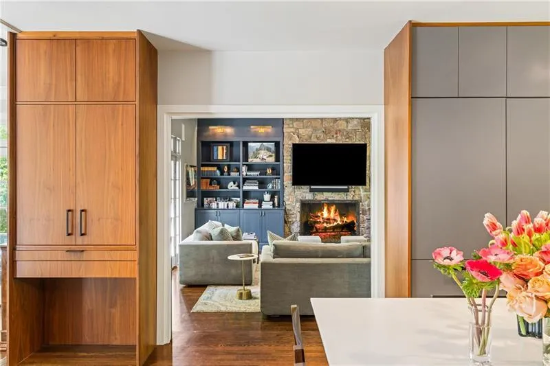 Living room featuring dark wood-style floors and a stone fireplace