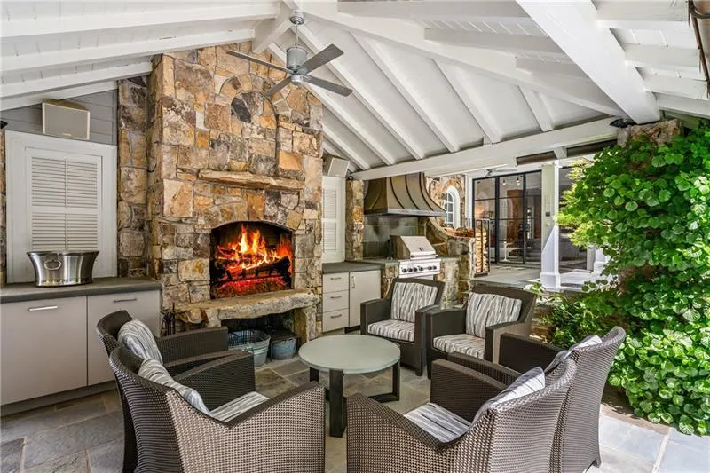 View of patio / terrace with exterior kitchen, an outdoor living space with a fireplace, a grill, and ceiling fan