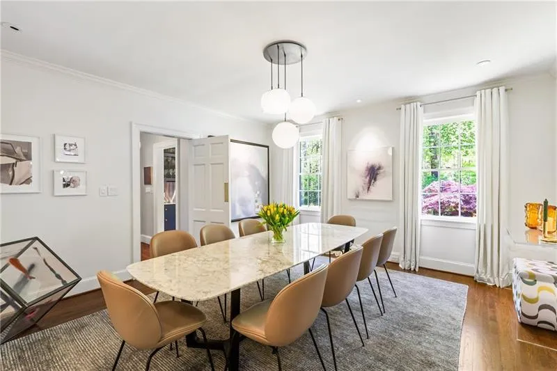 Dining space with crown molding, dark wood finished floors, and baseboards