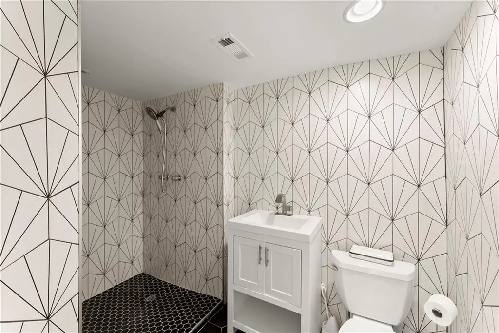 4th Bathroom featuring tiled shower and vanity