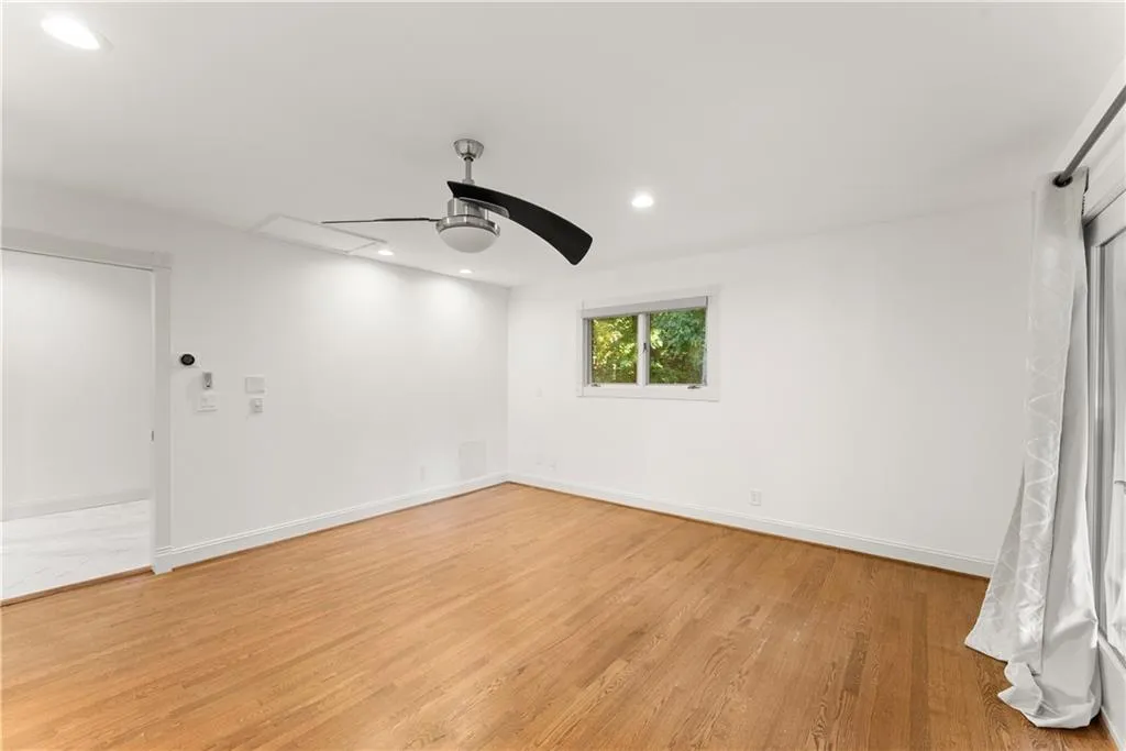 Unfurnished room featuring light wood finished floors, recessed lighting, a ceiling fan, and attic access