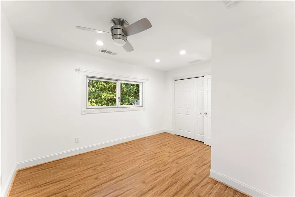 Unfurnished bedroom featuring light wood finished floors, ceiling fan, a closet, and recessed lighting