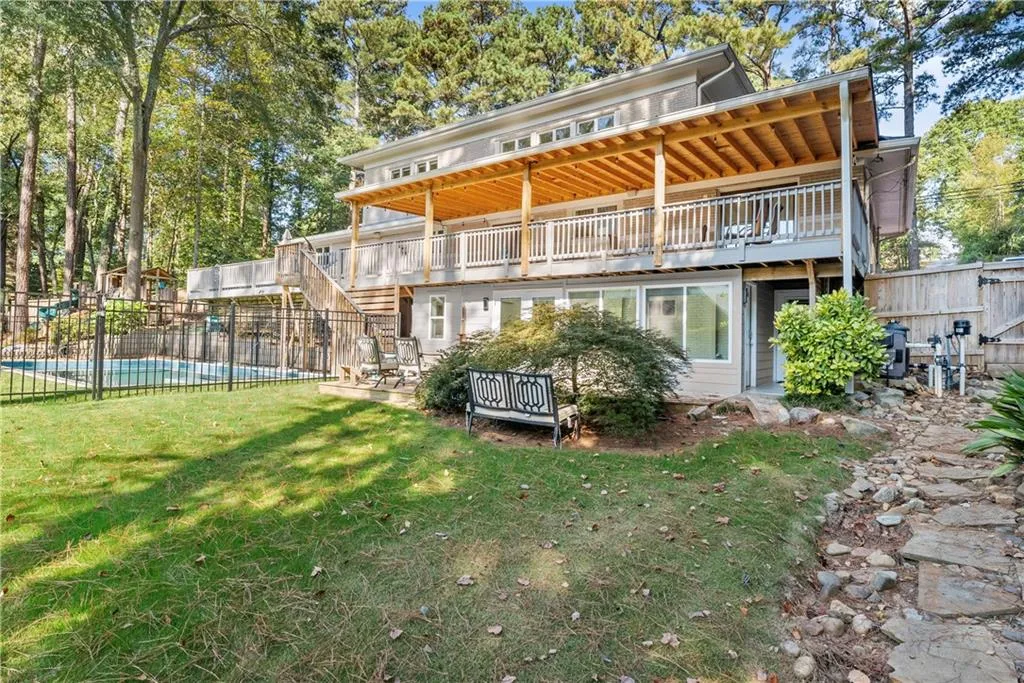 Rear view of house with stairs, a wooden deck, and a patio area