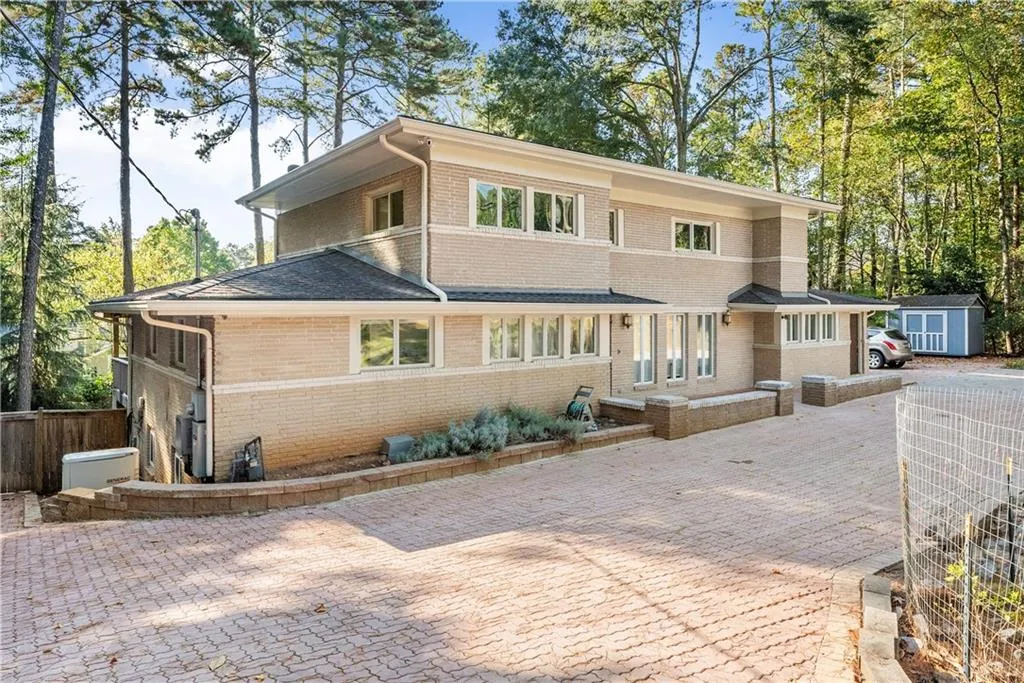 View of front of property featuring a storage unit and brick siding