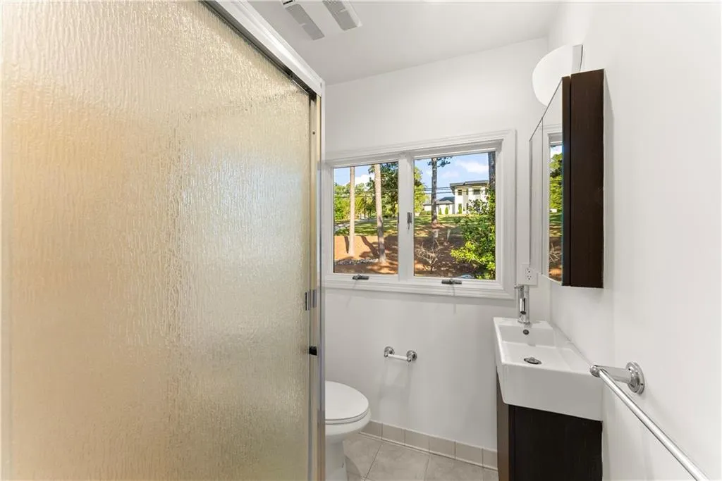 Full bathroom with vanity, a shower stall, and light tile patterned floors