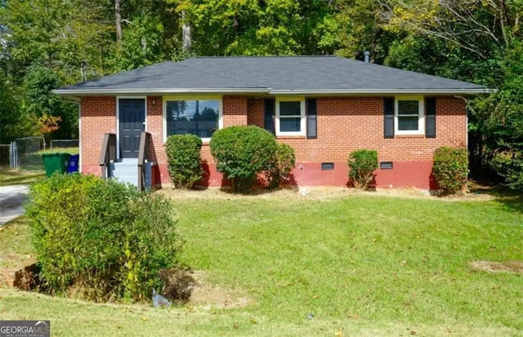 Brick exterior with a dark shingle roof, featuring white-framed windows with dark shutters