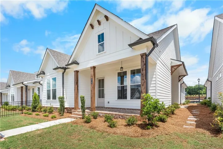 Modern inspired farmhouse with a porch, board and batten siding, and a shingled roof. Photo does not represent actual property but similar