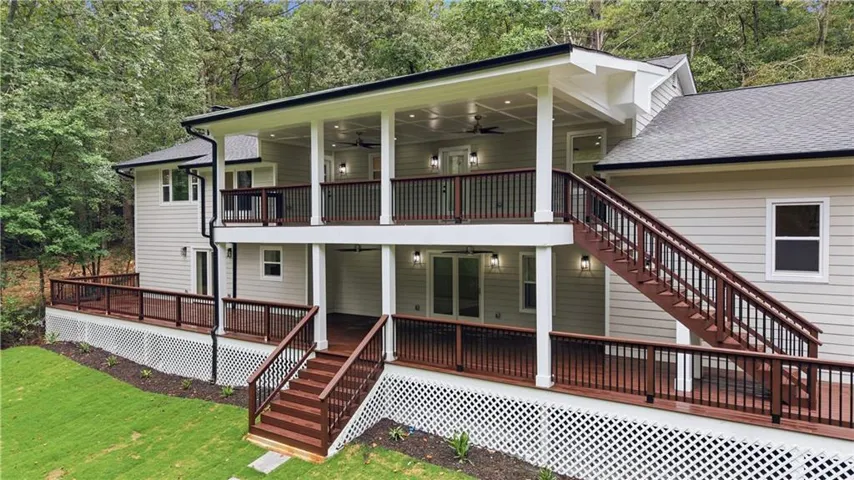 Multi-level rear decks featuring stained wood flooring, white railings, and integrated lighting