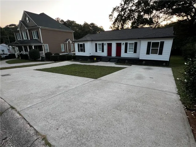 View of front of property with a lawn and driveway