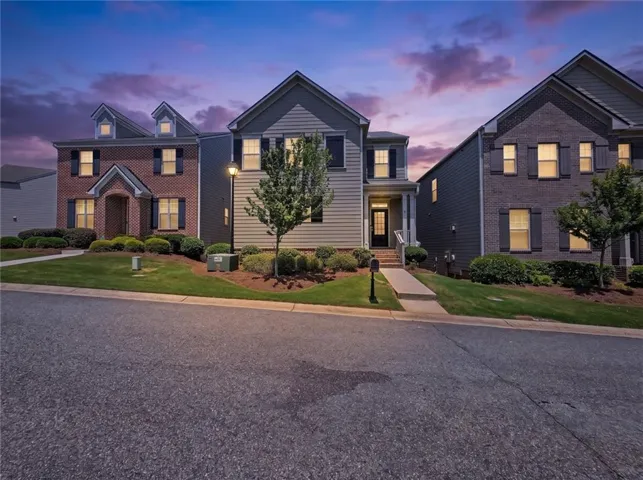 Two-story home with light-toned siding and dark shutters