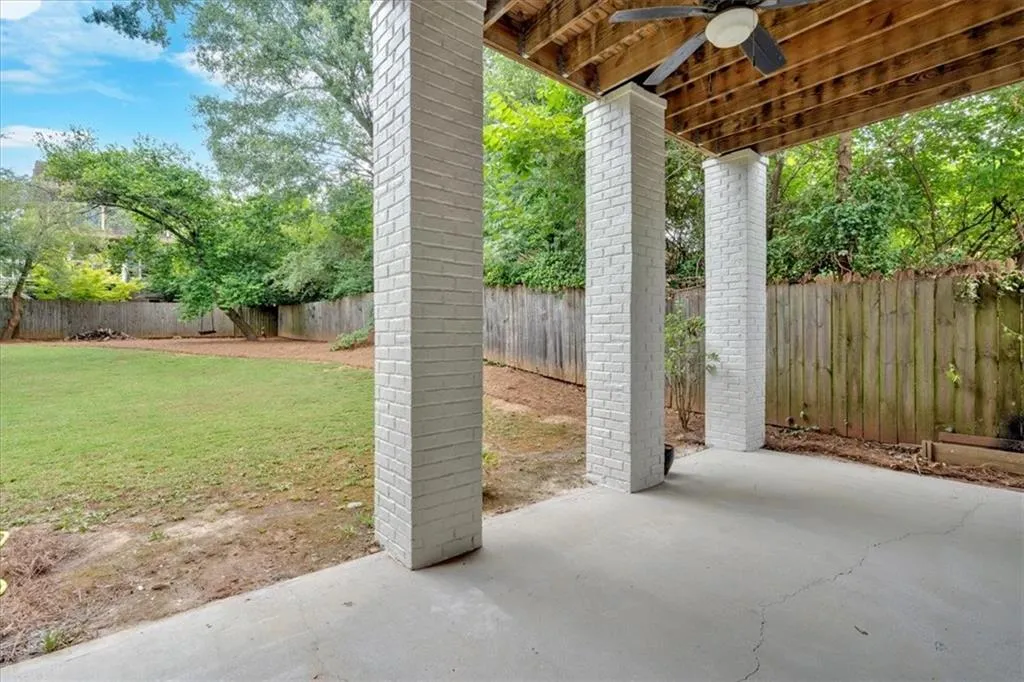 Fenced backyard featuring a ceiling fan and a patio
