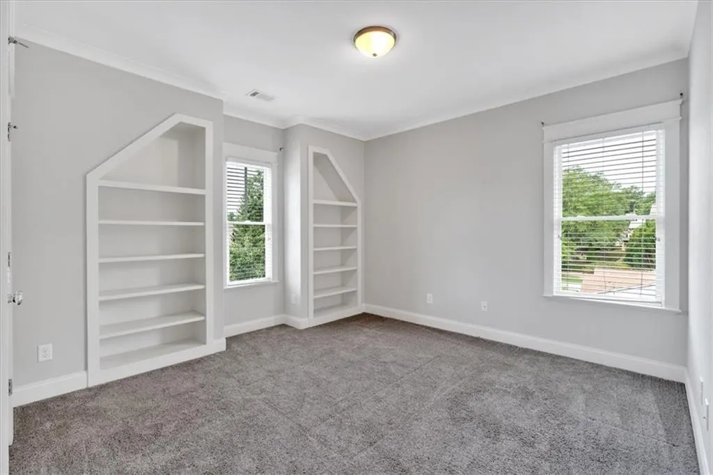 Carpeted spare room featuring ornamental molding and baseboards