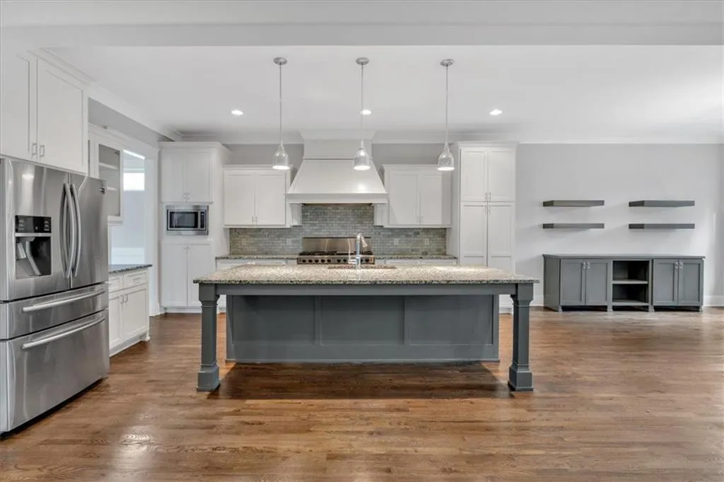 Kitchen with appliances with stainless steel finishes, custom range hood, crown molding, white cabinetry, and recessed lighting
