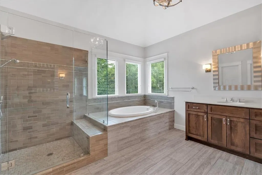 Bathroom featuring vanity, a bath, and a shower stall