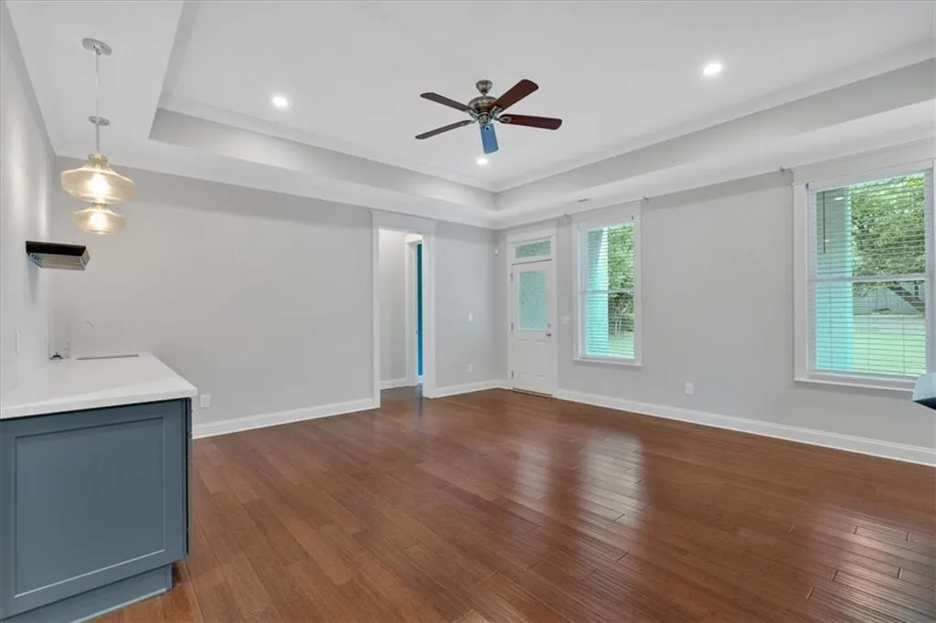 Unfurnished living room featuring ceiling fan, healthy amount of natural light, dark wood-type flooring, and recessed lighting