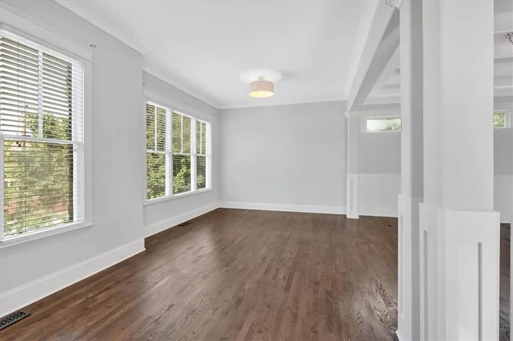 Empty room featuring healthy amount of natural light and dark wood-style floors