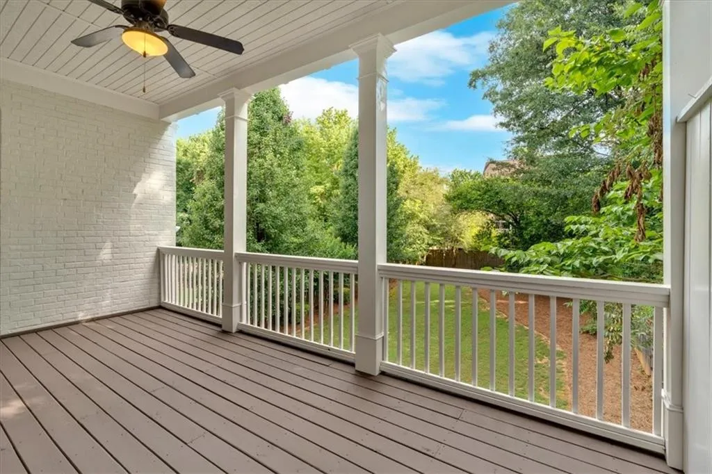 Wooden terrace with ceiling fan and a lawn