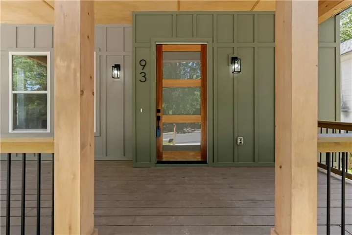 Front porch featuring wood-finish flooring, wood structural columns, and a board and batten wall