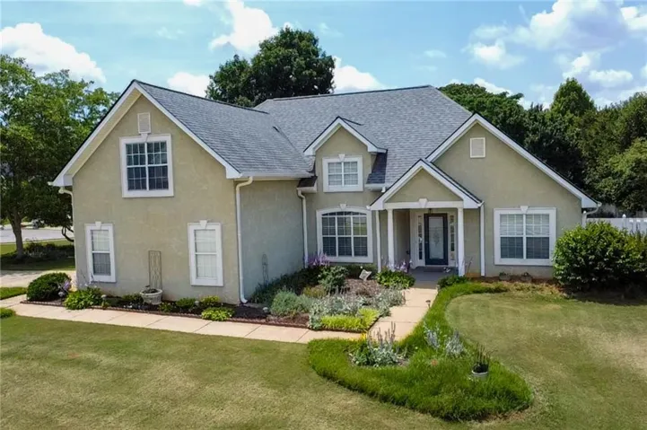 Two-story residence with a covered front entry, stucco exterior, and a shingled roof