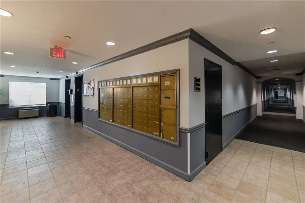 Hall with crown molding, recessed lighting, mail area, and light tile patterned floors