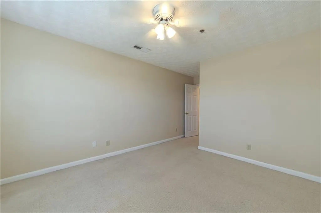 Spare room featuring light colored carpet and a textured ceiling