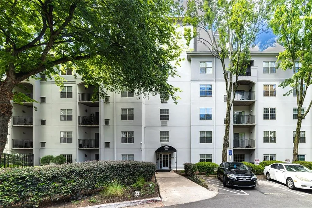 View of apartment building / complex featuring uncovered parking