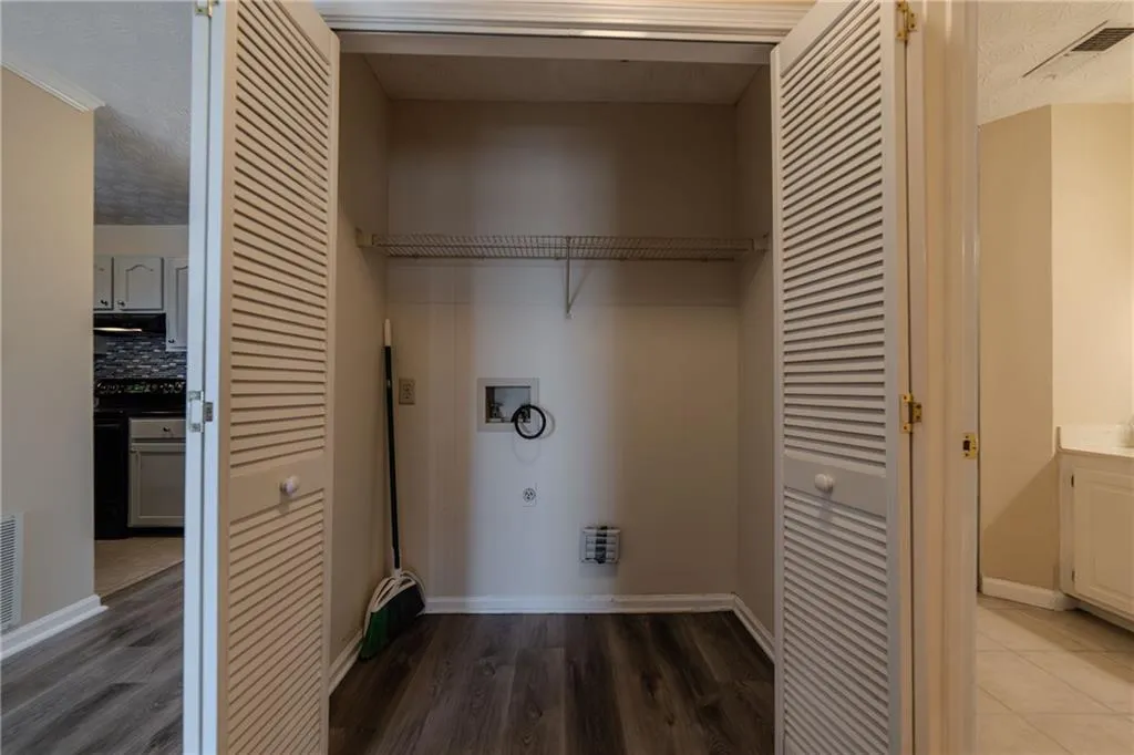 Washroom with washer hookup, a textured ceiling, hookup for an electric dryer, and wood finished floors