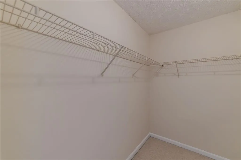 Spacious closet with light colored carpet