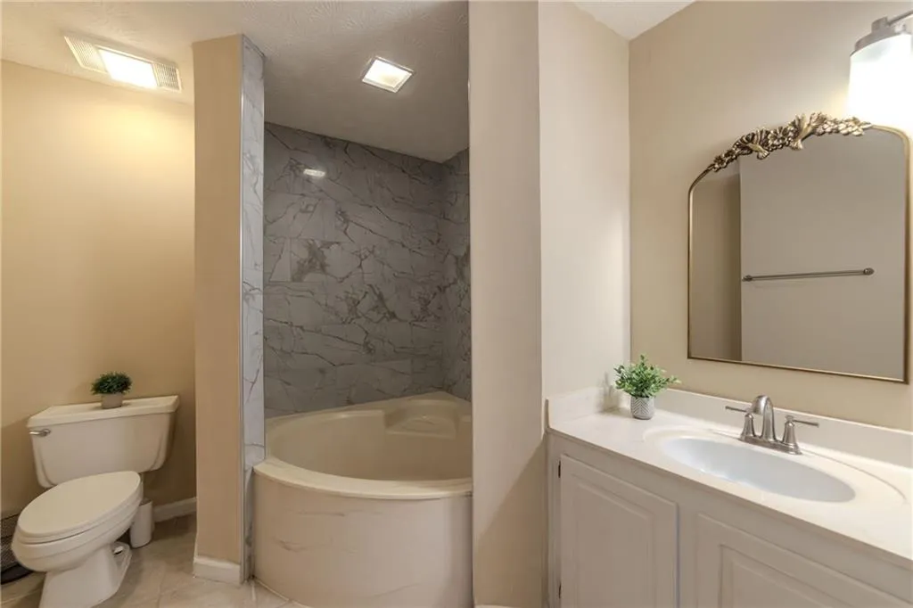 Full bathroom featuring vanity, a textured ceiling, and a combined bath / shower with marble appearance