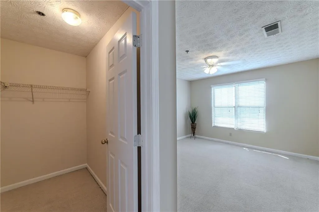 Walk in closet with carpet and ceiling fan