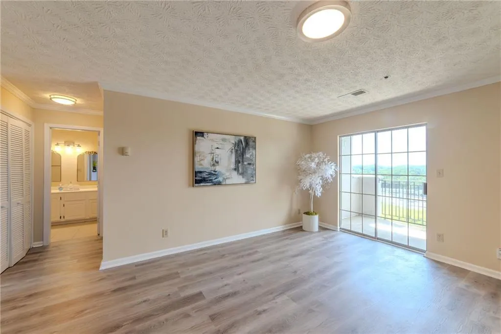 Spare room featuring ornamental molding, light wood-style floors, and a textured ceiling