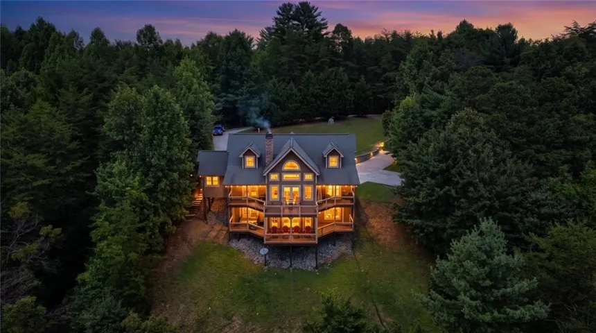 Expansive lodge-style residence featuring multiple balconies, prominent dormer windows, and a multi-level deck