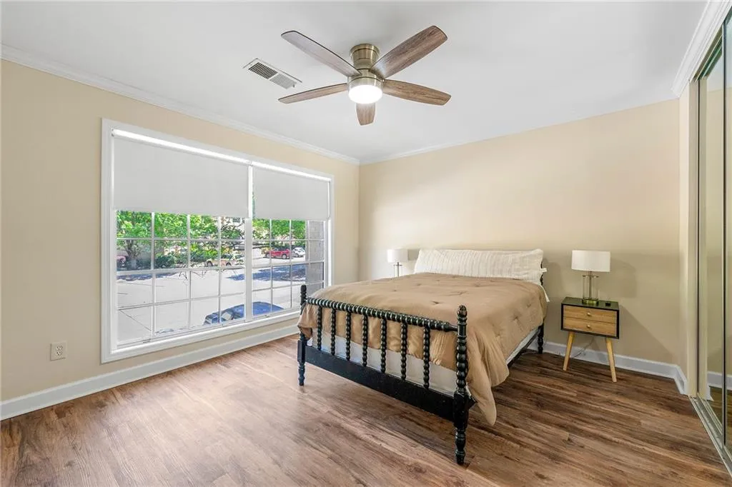 Bedroom with visible vents, baseboards, ornamental molding, and wood finished floors