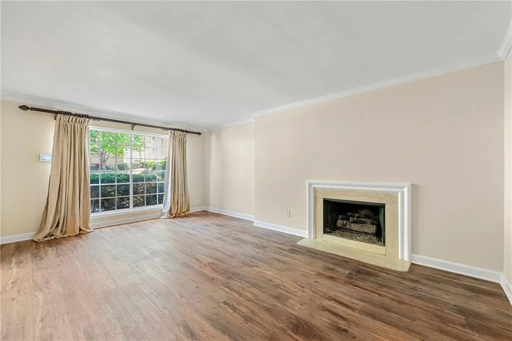 Unfurnished living room with ornamental molding, baseboards, and wood finished floors