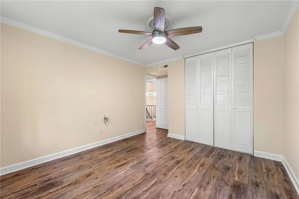 Unfurnished bedroom featuring wood finished floors, baseboards, a closet, and visible vents
