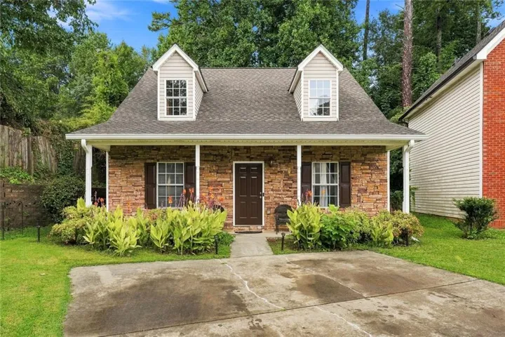 Stone veneer facade with a covered front porch and two dormer windows