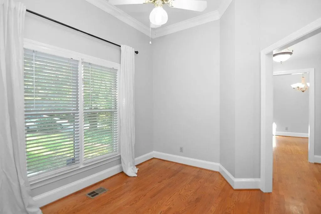 Living/den/office room featuring crown molding, hardwood finished floors, and a ceiling fan