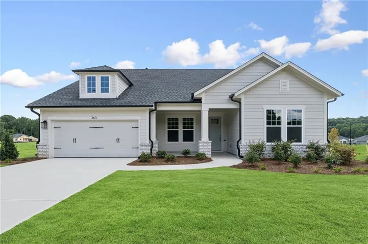 Contemporary ranch-style exterior with light gray siding, white brick accents, and a dark shingle roof