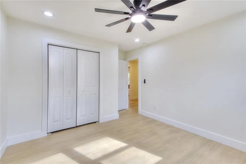 Unfurnished bedroom featuring light wood-style flooring, ceiling fan, a closet, and recessed lighting