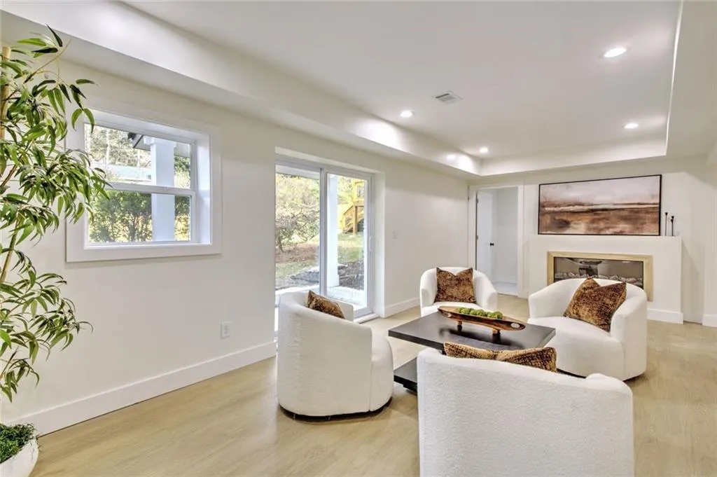 Sitting room featuring light wood-style flooring, recessed lighting, and a glass covered fireplace