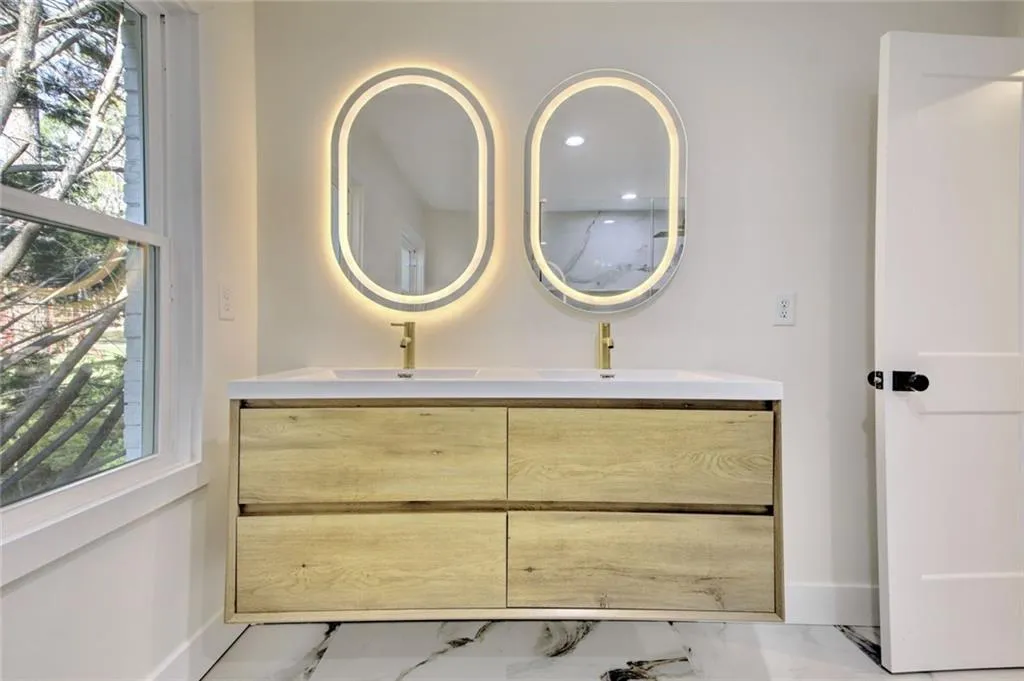 Full bath featuring light marble finish flooring, double vanity, and recessed lighting