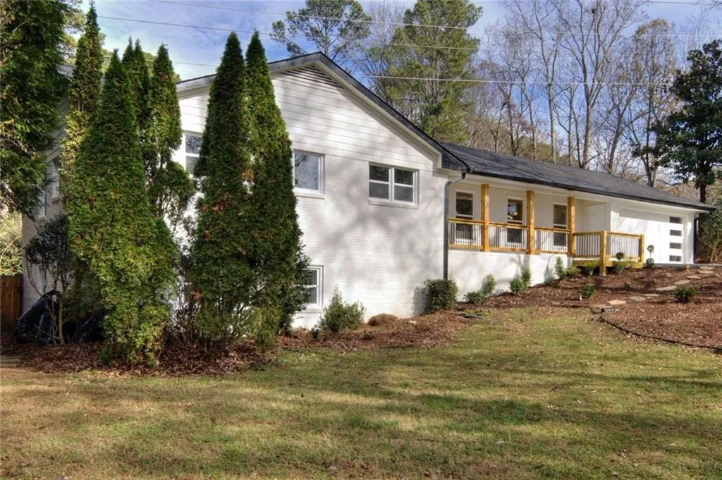 View of property exterior featuring a yard, covered porch, and brick siding
